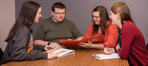 Photo of four students discussing a question in the classroom