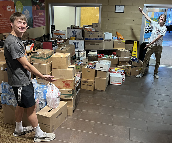 Two UJ Student Senate members point out the donations made for the Community Action food pantry. 