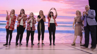 The women's soccer team waves to the crowd after winning the a contest at Dine and Bid.