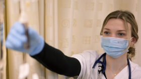 A nursing student adjusts an IV