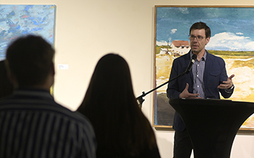 Aaron Cloyd speaking at podium at Plainsong Launch Party.