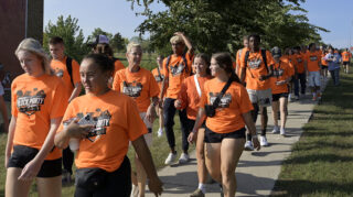 President Polly Peterson walks with UJ students during the 2023 Community Block Party.