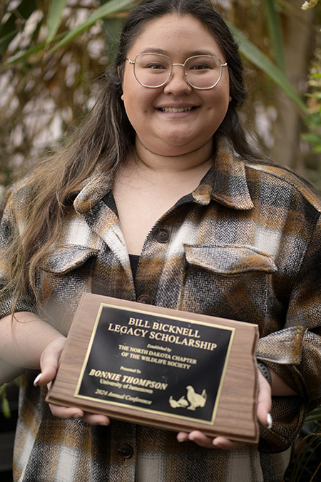 Bonnie Thompson holding her award that reads "Bill Bicknell Legacy Scholarship"