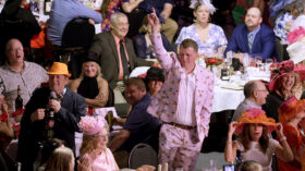 Guests watch the auctioneer during the Dine & Bid's Live Auction session.