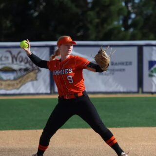 Softball player about to throw a fielded ball.