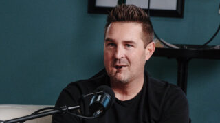 A man speaks into a microphone while recording a podcast.