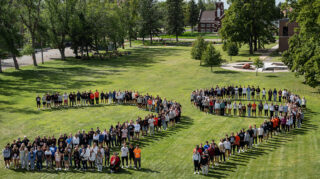 Crowd of students on a grassy area formed to make the number 