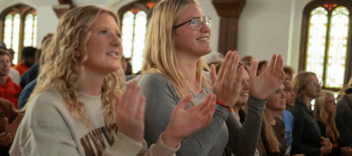 Students clap and worship inside Voorhees Chapel at the University of Jamestown during a Chapel service.