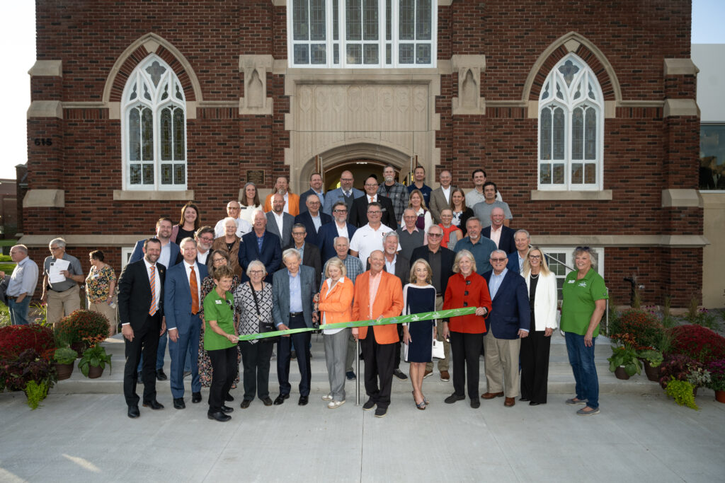  A group of people gathers in front of Voorhees Chapel for a ribbon-cutting ceremony, celebrating the dedication of the renovated chapel and the new Center for Faith and Life.