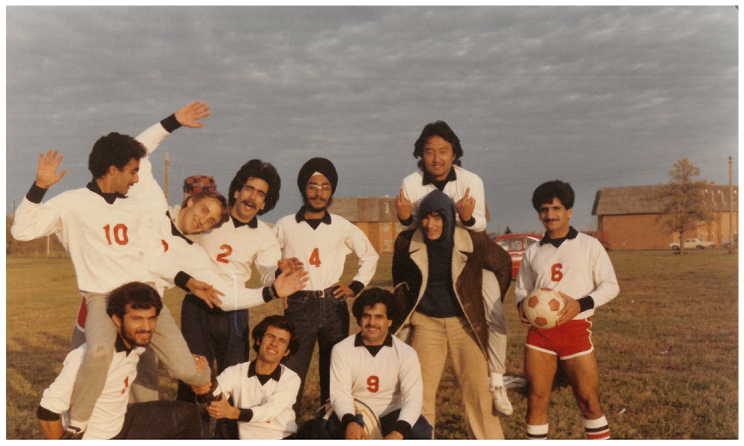 Soccer team group photo. A soccer team poses outdoors, showcasing camaraderie and humor.
