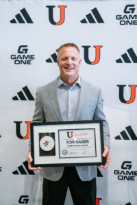 Man poses with award in front of UJ backdrop