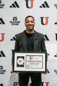 Man holds award in front of UJ backdrop