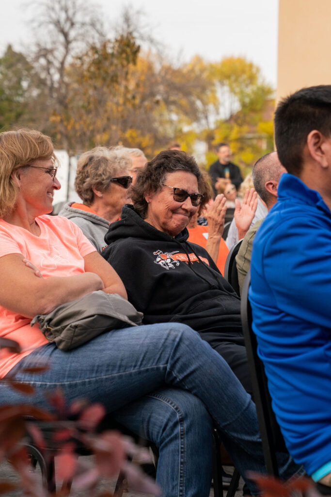 Woman smiling amongst crowd.