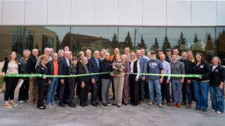 Group stands in front of new building and cuts ribbon to dedicate the space.