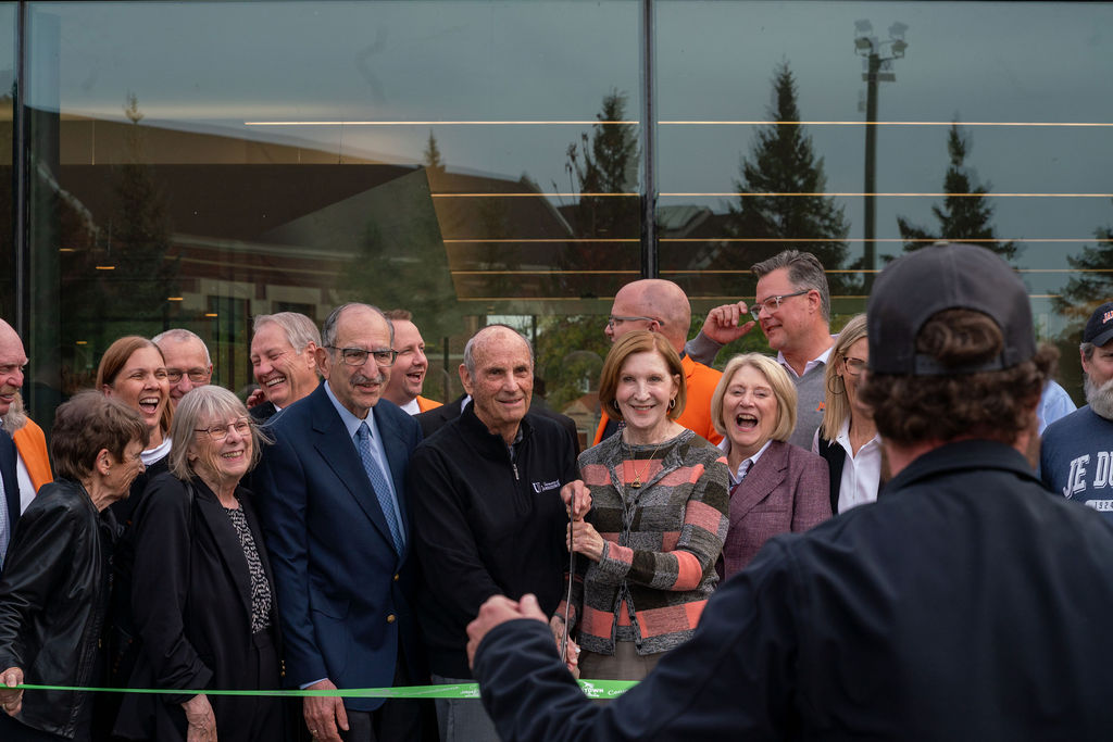 crowd members appear joyous after cutting ribbon at dedication ceremony